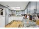 Light, bright kitchen featuring granite countertops, gray cabinets and light wood flooring at 1 Aberdeen Cir, Leesburg, FL 34788