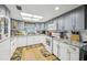 Bright kitchen featuring white appliances, granite counters, gray cabinets and a sunny window at 1 Aberdeen Cir, Leesburg, FL 34788