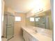 Bright bathroom featuring a glass-enclosed shower, a large mirror, and a white vanity with ample counter space at 10442 Se 179Th Pl, Summerfield, FL 34491