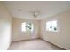 Comfortable bedroom featuring two windows for natural light, complemented by a ceiling fan at 10442 Se 179Th Pl, Summerfield, FL 34491