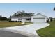 Inviting single-story home with a manicured lawn and long driveway to a two-car garage at 10442 Se 179Th Pl, Summerfield, FL 34491