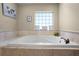 Relaxing tub area with tiled surround and glass block window at 11126 Oakshore Ln, Clermont, FL 34711