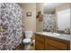Cozy bathroom features a single sink vanity and a shower with a decorative floral patterned curtain at 11126 Oakshore Ln, Clermont, FL 34711