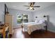 Sunlit bedroom featuring hardwood floors and a large window with a lovely view of the neighborhood at 11126 Oakshore Ln, Clermont, FL 34711