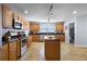 Bright kitchen featuring wood cabinets, stainless steel appliances, and a large kitchen island at 11126 Oakshore Ln, Clermont, FL 34711