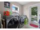 Functional laundry room featuring modern appliances, a large window, and convenient outdoor access at 11126 Oakshore Ln, Clermont, FL 34711