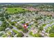 Aerial view of a neighborhood surrounded by lush green trees and foliage, community, and well-maintained roads at 1202 Del Toro Dr, Lady Lake, FL 32159