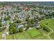 Aerial view showcases the community, including lawn bowling, a pool, parking, and neighboring residential areas at 1202 Del Toro Dr, Lady Lake, FL 32159