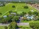 Aerial view showcases community amenities with green spaces, pool, clubhouse, parking, and nearby homes at 1202 Del Toro Dr, Lady Lake, FL 32159