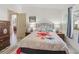 Bedroom with wood-look flooring, bed with floral bedding, and window with curtain at 1202 Del Toro Dr, Lady Lake, FL 32159