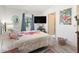 Bedroom with wood-look flooring, large TV, window with curtains, and a decorative round mirror at 1202 Del Toro Dr, Lady Lake, FL 32159
