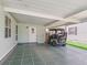 Carport with tiled floor and a golf cart under a well-lit, covered parking area adjacent to the house at 1202 Del Toro Dr, Lady Lake, FL 32159