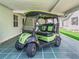 Carport featuring a green and black golf cart with stylish rims under a covered parking area at 1202 Del Toro Dr, Lady Lake, FL 32159