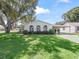 Charming single-story home featuring well-maintained landscaping, a carport, and classic architectural details at 1202 Del Toro Dr, Lady Lake, FL 32159