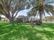 Charming single-story home featuring a lush green lawn, mature trees, and inviting curb appeal at 1202 Del Toro Dr, Lady Lake, FL 32159