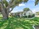 Single story home with well-manicured lawn, mature trees, attractive landscaping, and charming curb appeal at 1202 Del Toro Dr, Lady Lake, FL 32159