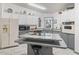 Cozy kitchen featuring white and gray cabinets, tile floor, and stainless appliances at 1202 Del Toro Dr, Lady Lake, FL 32159