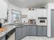 Charming kitchen featuring white and gray cabinets, tile floor, and granite countertops at 1202 Del Toro Dr, Lady Lake, FL 32159