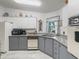 Classic kitchen with white and gray cabinetry, tile floors, and granite countertops at 1202 Del Toro Dr, Lady Lake, FL 32159