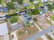 Aerial view of a home with solar panels, a detached garage, canal access, and well-maintained landscaping at 12401 Blue Heron Way, Leesburg, FL 34788