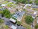 Aerial view of a home with a screened-in pool, solar panels, and a canal with a covered boat dock at 12401 Blue Heron Way, Leesburg, FL 34788