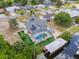 Aerial view of a home with a screened-in pool, solar panels, fenced yard, and canal access with a covered dock at 12401 Blue Heron Way, Leesburg, FL 34788