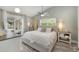 Bright bedroom with a ceiling fan, light gray walls, and sliding glass doors to the pool at 12401 Blue Heron Way, Leesburg, FL 34788