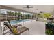 Relaxing screened-in outdoor pool area with chaise lounges and ceiling fans for comfort at 12401 Blue Heron Way, Leesburg, FL 34788