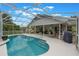 Outdoor swimming pool in the backyard with clear blue water, surrounded by a screened enclosure at 12401 Blue Heron Way, Leesburg, FL 34788