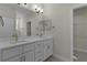 Bathroom with double vanity, white cabinets, and modern fixtures at 12624 Ne 49Th Dr, Oxford, FL 34484
