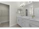 Bright bathroom with double vanity, white cabinets, granite counters, and a walk-in closet at 12624 Ne 49Th Dr, Oxford, FL 34484