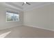 Bright bedroom with large window, light wood floors, tray ceiling, and neutral paint at 12624 Ne 49Th Dr, Oxford, FL 34484