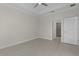 Spacious bedroom featuring tray ceiling, ceiling fan, and access to walk-in closet at 12624 Ne 49Th Dr, Oxford, FL 34484