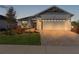Charming single-story home featuring a two-car garage and a professionally landscaped front yard at 12624 Ne 49Th Dr, Oxford, FL 34484
