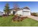 Beautifully landscaped front exterior with a three car garage and a brick paver driveway at 12624 Ne 49Th Dr, Oxford, FL 34484