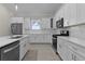 Bright kitchen with stainless steel appliances, island with sink, white cabinets, and backsplash at 12624 Ne 49Th Dr, Oxford, FL 34484