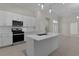 Modern kitchen features white cabinetry, stainless steel appliances, an island with sink, and an open floor plan at 12624 Ne 49Th Dr, Oxford, FL 34484