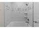 Bathroom featuring a tiled shower and tub with decorative accent tiles and shelving at 12624 Ne 49Th Dr, Oxford, FL 34484