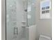 Modern shower with clear glass doors, tile accents, and built-in shelves at 12624 Ne 49Th Dr, Oxford, FL 34484