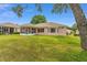 Spacious backyard featuring lush green grass and a screened-in lanai at 12687 Se 90Th Ter, Summerfield, FL 34491
