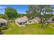 Expansive backyard with lush green grass, mature trees, and a screened-in lanai at 12687 Se 90Th Ter, Summerfield, FL 34491