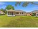 Wide backyard with a lush green lawn and a screened-in lanai at 12687 Se 90Th Ter, Summerfield, FL 34491