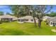 Well-maintained backyard featuring lush green grass, mature trees, and a screened-in lanai at 12687 Se 90Th Ter, Summerfield, FL 34491