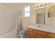Bathroom featuring a tub and shower combo with a colorful curtain, a oak vanity and tile flooring at 12687 Se 90Th Ter, Summerfield, FL 34491