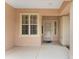 Covered front porch featuring a white framed window, matching door, and concrete flooring at 12687 Se 90Th Ter, Summerfield, FL 34491
