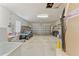 Spacious two car garage with a golf cart, shelving and lighting at 12687 Se 90Th Ter, Summerfield, FL 34491