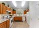 Well-lit kitchen features white appliances, tile floor and plenty of oak cabinets at 12687 Se 90Th Ter, Summerfield, FL 34491