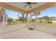 Screened-in lanai featuring concrete flooring and a ceiling fan overlooking the well-maintained yard at 12687 Se 90Th Ter, Summerfield, FL 34491