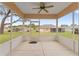 Covered lanai with a concrete floor and a panoramic view of the lush backyard and neighboring homes at 12687 Se 90Th Ter, Summerfield, FL 34491