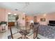 Open concept living room and kitchen with tile floors, ceiling fans and a glass dining table at 12687 Se 90Th Ter, Summerfield, FL 34491